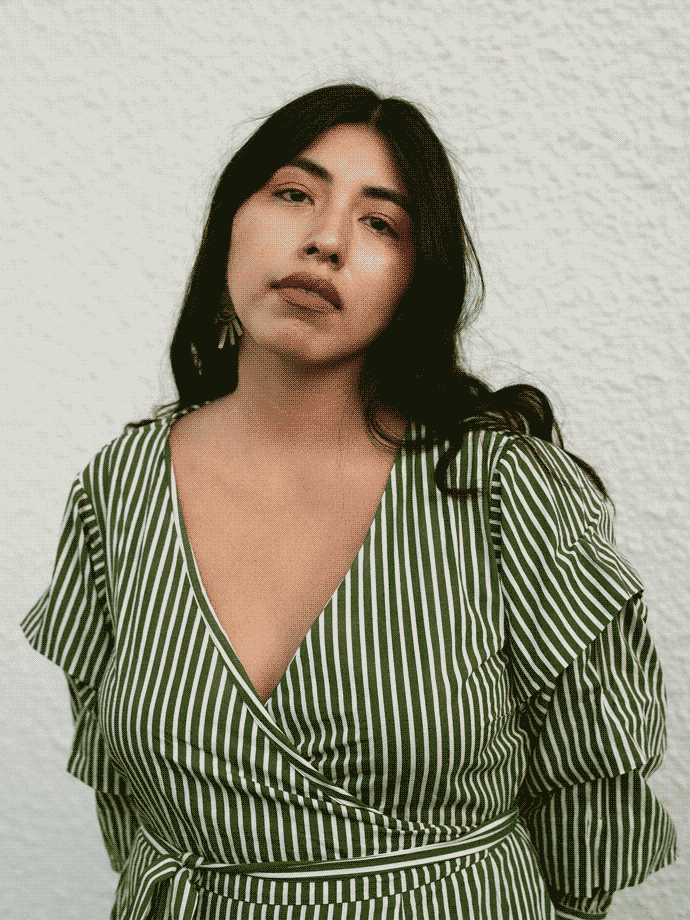 Photo of Gladys Camilo. 
                She is facing the camera with a serene expression on her face. Her hands are resting behind 
                her back as she tilts her head slightly to the left. She is wearing a green and white stripped
                dress.