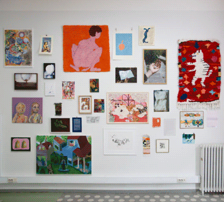 a white wall in a gallery spaced filled with artworks by various artists 
                    ranging in size and media.