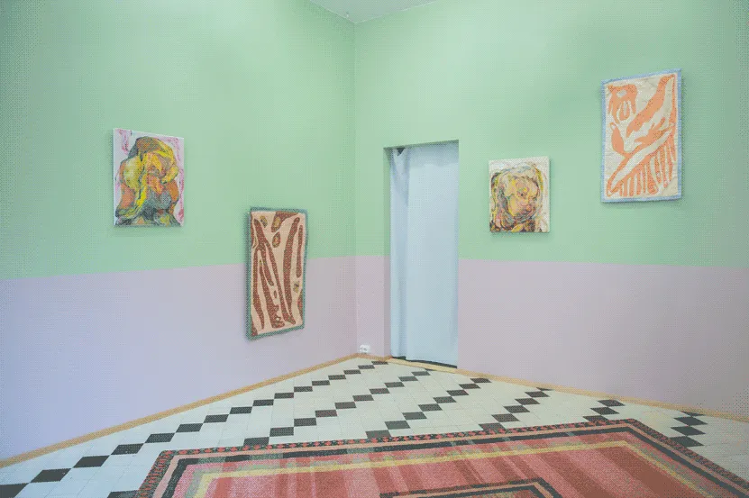 The same space, but from a different angle. From left to right, on the wall 
                    there is: the yellow painting, the brown quilt, a brown paintinh of a human-like
                    figure and a small pink quily with organic shapes. 