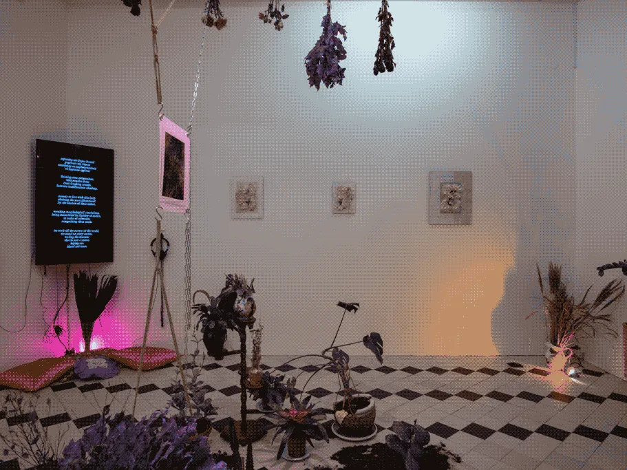 The same space, but from another angle. On the corner of the room hags a television playing a
                    video, and on the wall, hang three rya artworks.